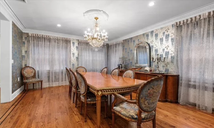 Dining space featuring an inviting chandelier, ornamental molding, and light hardwood / wood-style floors