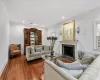 Living room featuring crown molding, dark wood-type flooring, a wealth of natural light, and a high end fireplace