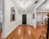 Foyer entrance featuring wood-type flooring, ornamental molding, and a chandelier