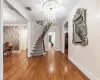 Entrance foyer featuring hardwood / wood-style flooring, ornamental molding, and a chandelier