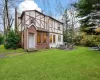 Rear view of property with a lawn and a patio area