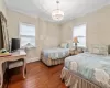 Bedroom with an inviting chandelier, hardwood / wood-style floors, and crown molding