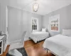 Bedroom with a notable chandelier, wood-type flooring, and ornamental molding