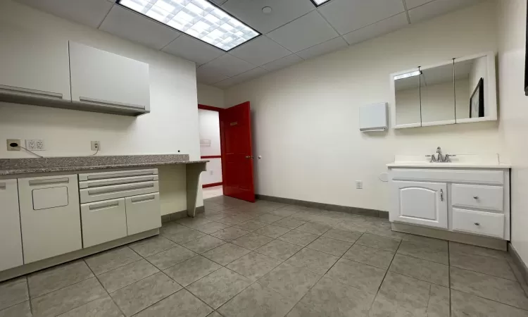 Kitchen featuring white cabinetry, sink, and light tile patterned floors