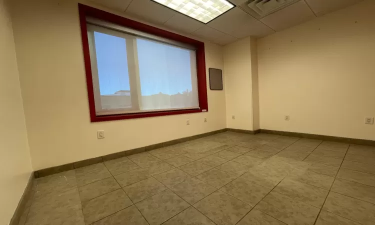 Unfurnished room with light tile patterned floors and a paneled ceiling