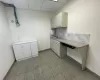 Kitchen featuring sink, light tile patterned floors, a paneled ceiling, white cabinetry, and tasteful backsplash