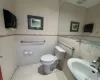 Bathroom with sink, tile walls, tile patterned floors, and toilet