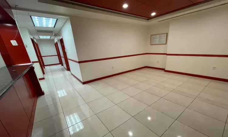 Tiled spare room with a raised ceiling