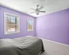 Bedroom featuring ceiling fan, light colored carpet, and baseboard heating