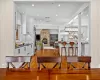 Kitchen featuring a center island, appliances with stainless steel finishes, white cabinets, decorative light fixtures, and wall chimney exhaust hood