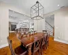 Living area featuring an inviting chandelier, wood-type flooring, a healthy amount of sunlight, and vaulted ceiling