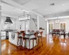 Kitchen featuring white cabinetry, decorative backsplash, a kitchen breakfast bar, a kitchen island, and wall chimney exhaust hood