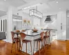 Kitchen featuring decorative backsplash, white cabinetry, range with gas cooktop, and wall chimney exhaust hood