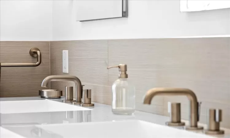 Bathroom with tile patterned floors, vanity, backsplash, tile walls, and toilet