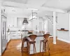 Bar with a baseboard radiator, sink, white cabinetry, decorative backsplash, and beverage cooler