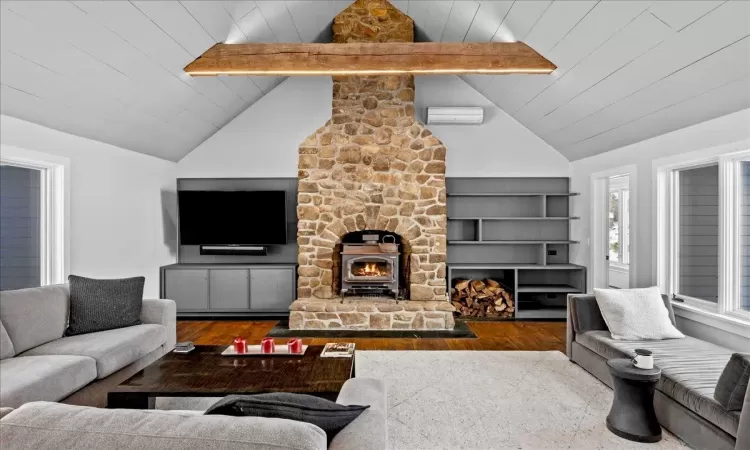 Living room featuring a wall mounted air conditioner, beamed ceiling, wooden ceiling, and hardwood / wood-style flooring