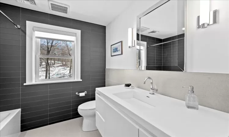 Bedroom featuring ceiling fan, carpet flooring, a baseboard heating unit, and multiple windows