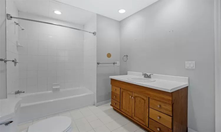 Full bathroom featuring toilet, vanity, tiled shower / bath, and tile patterned flooring