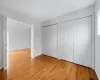 Unfurnished bedroom featuring light wood-type flooring and two closets