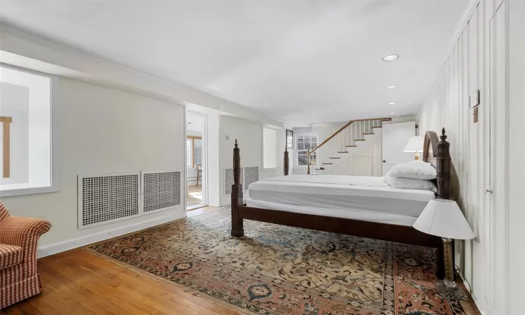 Lower Level Bedroom with ornamental molding and wood-type flooring