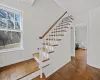 Staircase featuring a baseboard heating unit, ornamental molding, and parquet flooring