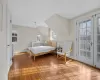 Bedroom with lofted ceiling, multiple windows, and light hardwood / wood-style flooring