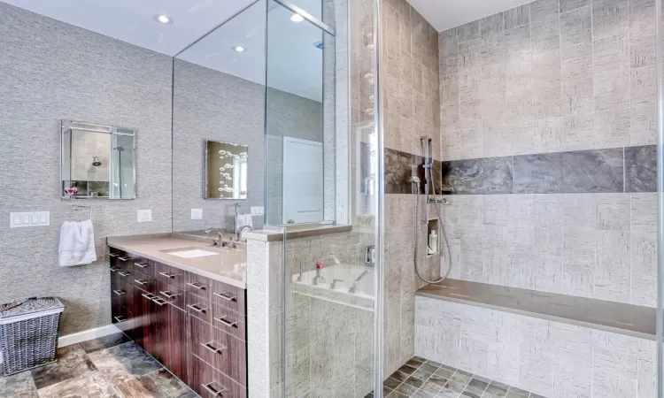 Bathroom featuring vanity, a shower, and tile walls