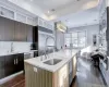 Kitchen featuring appliances with stainless steel finishes, tasteful backsplash, hanging light fixtures, a kitchen island with sink, and sink