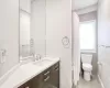 Bathroom with toilet, vanity, and tile patterned flooring