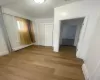 Unfurnished bedroom featuring a baseboard radiator, a closet, and light hardwood / wood-style flooring