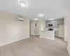 Kitchen with a wall mounted air conditioner, gray cabinets, kitchen peninsula, stainless steel appliances, and light hardwood / wood-style floors