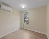 Spare room featuring a wall mounted air conditioner and light wood-type flooring