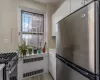 Kitchen featuring stainless steel appliances, white cabinetry, radiator, and light hardwood / wood-style floors