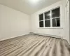 Unfurnished room featuring light wood-type flooring and baseboard heating