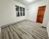 Unfurnished room featuring a baseboard heating unit and light hardwood / wood-style flooring