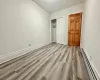 Unfurnished bedroom featuring light hardwood / wood-style floors, a closet, and a baseboard heating unit