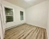 Spare room featuring a baseboard radiator and light hardwood / wood-style floors