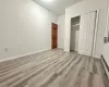 Unfurnished bedroom featuring a baseboard heating unit, light hardwood / wood-style floors, and a closet