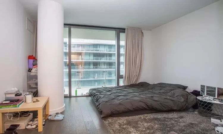 Bedroom featuring hardwood / wood-style floors and expansive windows