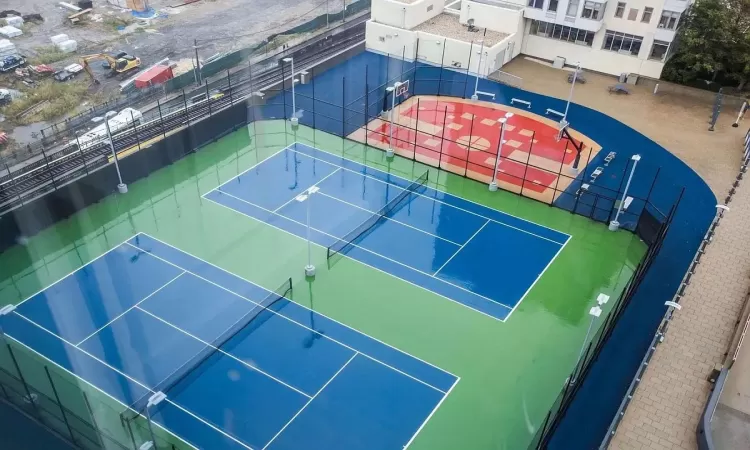 View of tennis court with basketball hoop