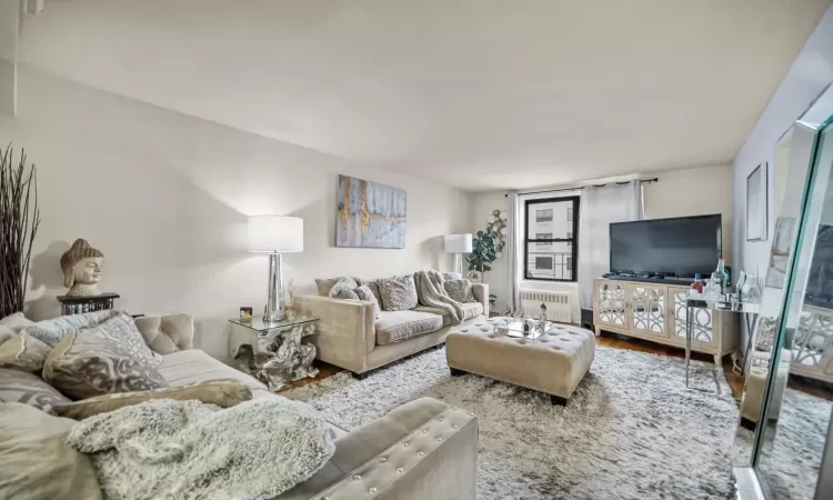 Living room featuring hardwood / wood-style flooring and radiator heating unit