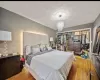 Bedroom with an inviting chandelier, light hardwood / wood-style floors, and a closet