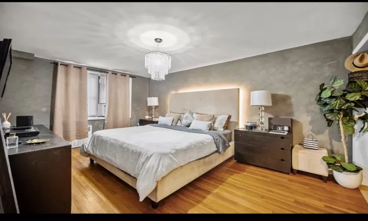 Bedroom featuring a notable chandelier and light hardwood / wood-style floors