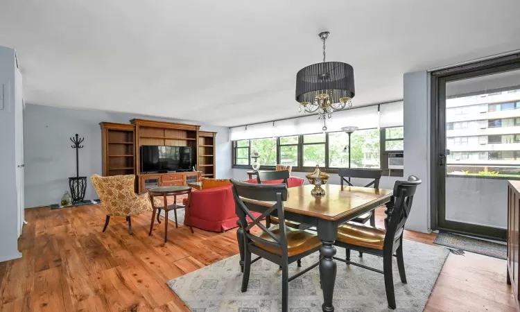 Dining space with wood-type flooring and a notable chandelier