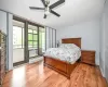 Bedroom featuring cooling unit, light hardwood / wood-style flooring, ceiling fan, and access to outside