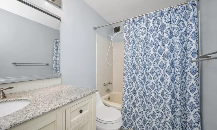 Bathroom featuring tasteful backsplash, vanity, and toilet