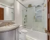 Full bathroom featuring vanity, toilet, and combined bath / shower with glass door