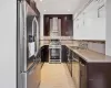 Kitchen featuring wall chimney exhaust hood, appliances with stainless steel finishes, and sink