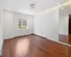 Empty room featuring dark wood-type flooring and baseboard heating