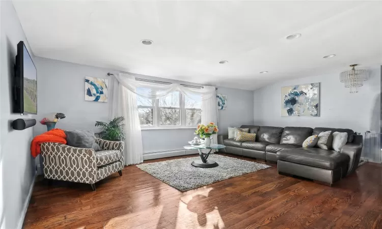 Living room featuring dark hardwood / wood-style flooring and a baseboard heating unit